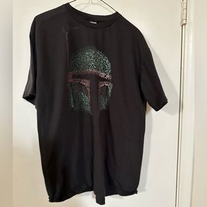This is a black t-shirt with an image of Mandalorian from Star Wars.